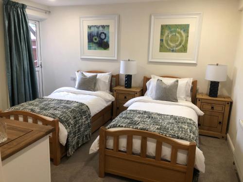 a bedroom with two beds and two tables with lamps at South Avenue B&B in Oxford
