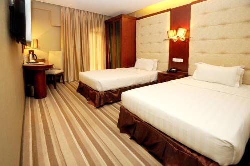 ein Hotelzimmer mit 2 Betten und einem TV in der Unterkunft Celyn City Hotel in Kota Kinabalu