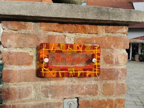 a sign on the side of a brick wall at Gästezimmer Reitinger in Siegenburg