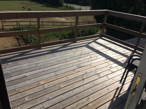 a wooden deck with a fence and a chair at Lejlighed på landet, NO Smoking in Kvistgård