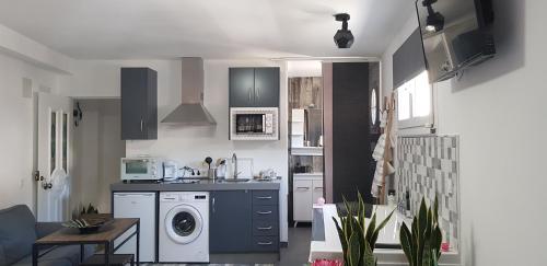 a kitchen with a sink and a washing machine at El nido de la Galería in Setenil