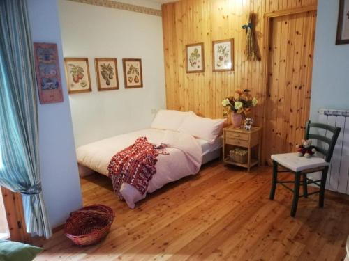 a bedroom with a bed and a wooden floor at La Casetta delle Fate all'Abetone in Abetone