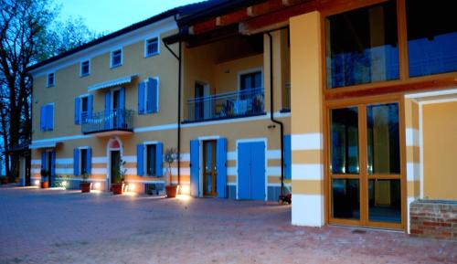 un gran edificio con puertas y ventanas azules en AGRICOLA GODINO B&B, en Ozzano Monferrato