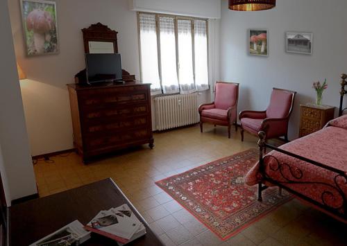 a living room with a bed and two chairs at Albergo Ristorante La Rocca in Firenzuola