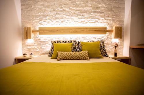 a bedroom with a yellow bed with a brick wall at Nirvana in Sierra Nevada