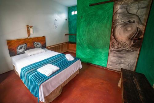 um quarto com uma cama com um quadro na parede em Galapagos Morning Glory em Puerto Ayora