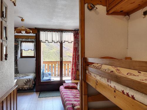 een slaapkamer met een stapelbed en een raam bij Nid aux Menuires in Les Menuires