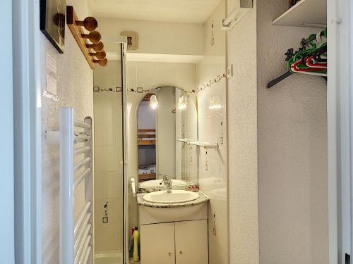een badkamer met een wastafel en een spiegel bij Nid aux Menuires in Les Menuires