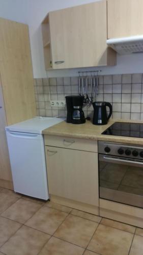 a kitchen with white cabinets and a stove top oven at Gästewohnung zum Wohlfühlen in Döbeln