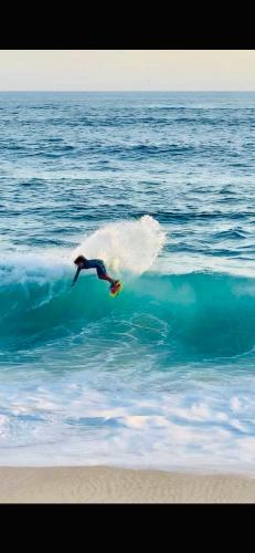 a person riding a wave on a surfboard in the ocean at Colibri Hotel in Cabo Corrientes