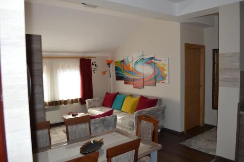 a living room with a couch with colorful pillows at Apartmani DUGA Milmari in Kopaonik