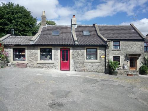a stone house with a red door at Swan walkers cottage in Bath