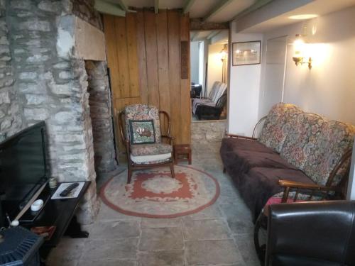 a living room with a couch and a tv at Swan walkers cottage in Bath