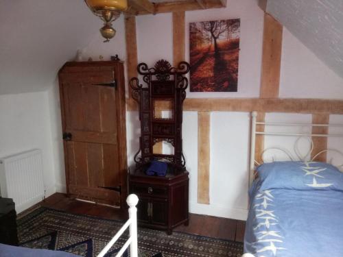 a bedroom with a bed and a dresser and a mirror at The Old Swan walkers cottage in Bath