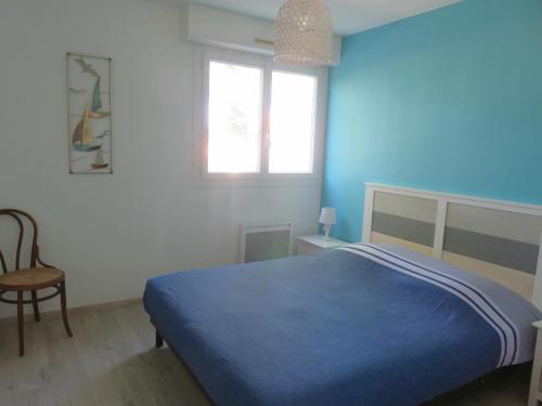 une chambre avec un lit bleu et une fenêtre dans l'établissement Grand T2 vue mer calme climatisé 500 m village et plage parking gratuit, à Sanary-sur-Mer
