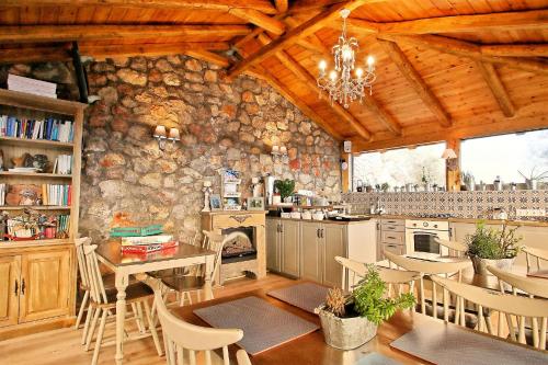 a kitchen and dining room with a stone wall at AlmondHouse Suites with Fireplace - ADULTS ONLY in Arachova