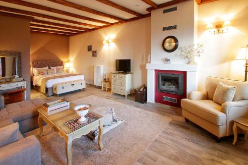 a living room with a bed and a fireplace at AlmondHouse Suites with Fireplace - ADULTS ONLY in Arachova