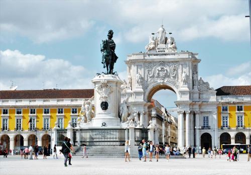 a statue in front of a building with people walking around it at Casa Portuguesa Fanqueiros in Lisbon