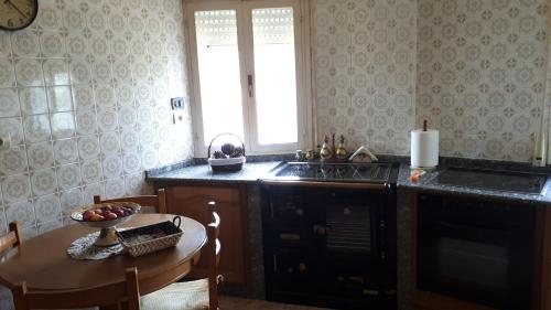 a kitchen with a table and a sink and a window at CASA PUMARES in Lagoa