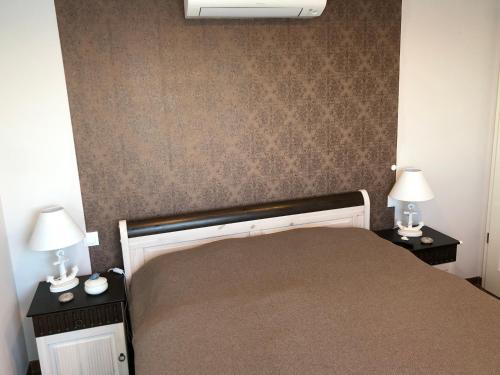 a bedroom with a bed with two night stands and two lamps at Hausboot Elandi in Bitterfeld