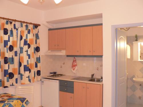 a kitchen with wooden cabinets and a sink at Stolidi in Adamas