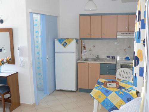 a small kitchen with a table and a refrigerator at Stolidi in Adamas