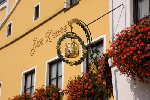 a building with flowers and a chandelier in front of it at Hotel Zur Krone in Beilngries