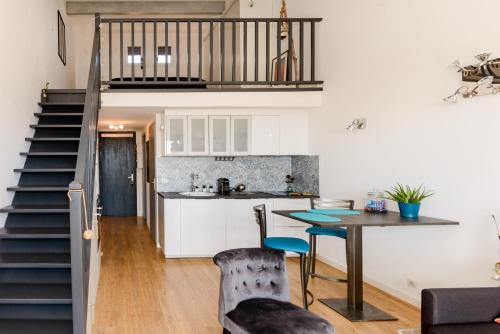 eine Küche und ein Wohnzimmer mit einem Tisch und einer Treppe in der Unterkunft A 2 pas de la Mer in Sausset-les-Pins