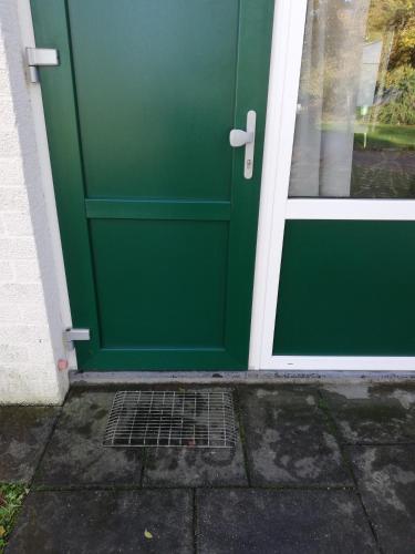 a green front door of a house at Rustige, gelijkvloerse vakantiewoning met 2 slaapkamers in Simpelveld, Zuid-Limburg in Simpelveld
