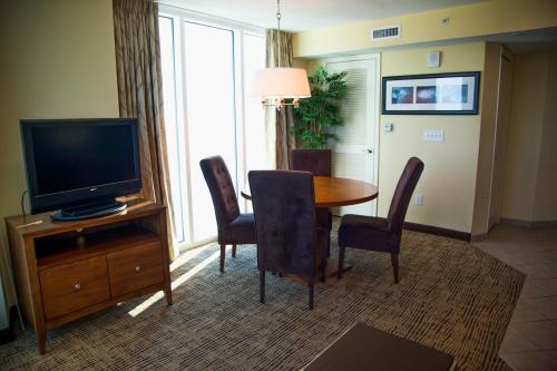 a living room with a television and a table and chairs at Towers at North Myrtle Beach in Myrtle Beach