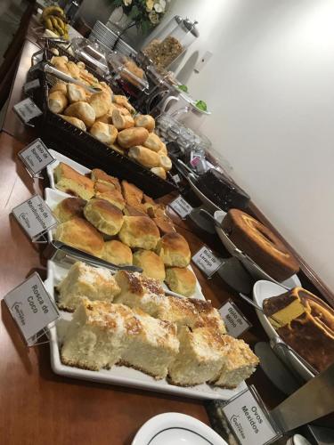 a buffet of bread and pastries on a table at Hotel Garrafão - Rua Principal de Boituva in Boituva