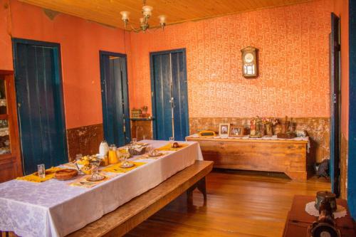 a large room with a table and a kitchen at Hospedaria Vó Zazá in Carrancas