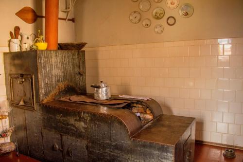 a kitchen with an old wooden oven in a room at Hospedaria Vó Zazá in Carrancas