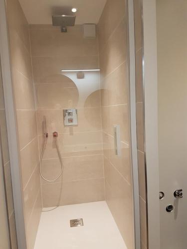 une salle de bain avec une douche avec une porte vitrée dans l'établissement Les étoiles de la plagne le Diamant, à Mâcot La Plagne