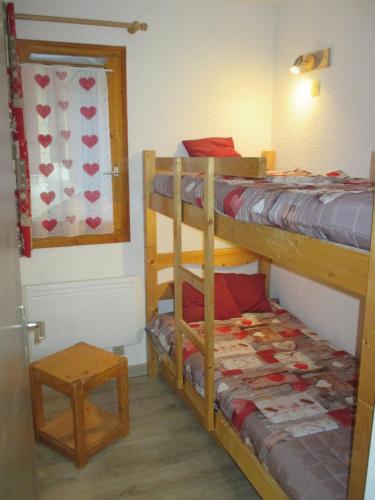 une chambre avec deux lits superposés et une table dans l'établissement appartement 4 personnes Armancette, aux Contamines-Montjoie