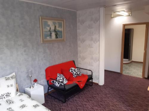 a bedroom with a red chair and a bed at casa di Gino in Antwerp