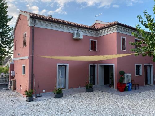a pink building with a yellow ribbon in front of it at B&B La Grancia in Chiaravalle