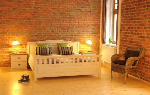 a bedroom with a bed and a brick wall at Time Cafe & Penzion in Příbram