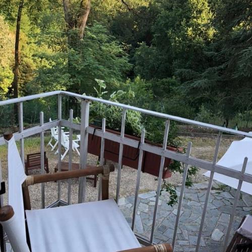 a balcony with chairs and a table and trees at Tenuta Nissole in Rocchetta Tanaro
