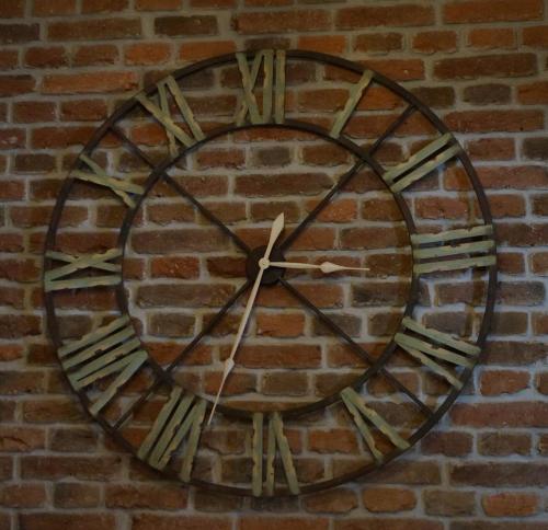 a large clock on the side of a brick wall at Time Cafe & Penzion in Příbram