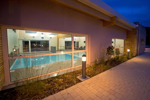 a house with a swimming pool at night at Résidence Les Rives de la Fecht - Colmar Ouest in Ingersheim