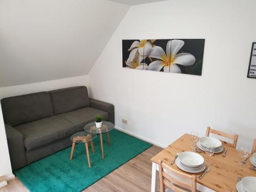 ein Wohnzimmer mit einem Sofa und einem Tisch in der Unterkunft Wohlfühl-Apartment Bad Kissingen III in Bad Kissingen