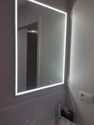 a bathroom with a large mirror above a sink at cité impériale ye in Mettet