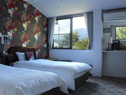 輕井澤的住宿－維利斯酒店，酒店客房设有两张床和窗户。