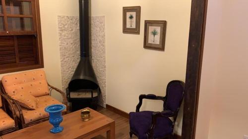 a living room with a chair and a fireplace at Refúgio das Araucárias in Ibiúna