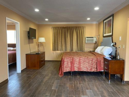 una stanza d'albergo con un letto e una finestra di Villa Park Motel a Orange