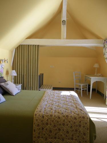 une chambre avec un lit, une table et un bureau dans l'établissement La Petite Varenne, à Turny