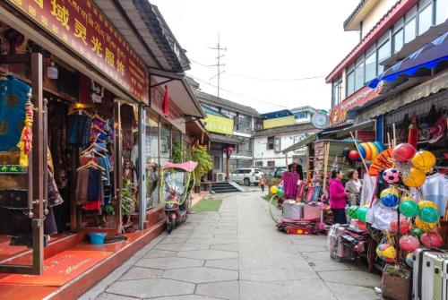 a street with a group of shops and people walking down the street at Holly's Hostel in Chengdu