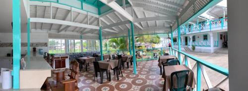 a restaurant with tables and chairs in a building at Villa Sunny Days in San Andrés
