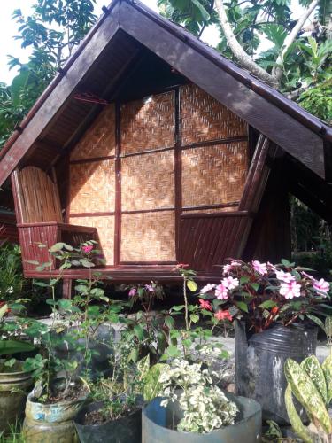 a small house with a window and a bench at LHOYJEAN Garden Hostel in Batuan